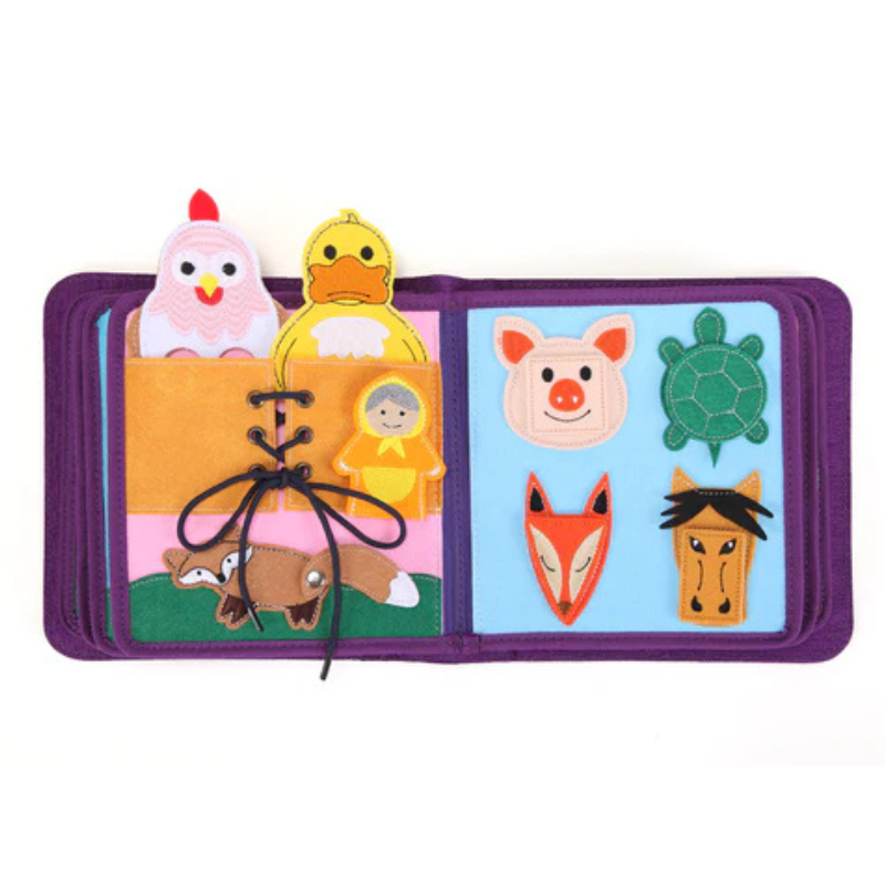Märchenwelten Quiet Book Doppelseite: links Fädel-/Schnürübung mit Schleife, dazu Huhn und Ente in der Tasche, rechts abnehmbare Filz-Tiergesichter (Schwein, Schildkröte, Fuchs, Pferd) zum Zuordnen – schult Feinmotorik. Ab 1 Jahr.